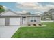 Well-maintained home features gray siding, a white garage door, brick accents and a lush green lawn at 1491 Coen Ct, Columbus, IN 47201