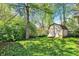 Lush backyard with mature trees, shrubs, and a storage shed at 1523 E Perry St, Indianapolis, IN 46227