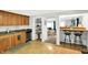 Well-lit kitchen with wood cabinets, stainless steel appliances, and a breakfast bar with stools at 1523 E Perry St, Indianapolis, IN 46227