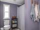 Cozy bathroom featuring a window, toilet, shelving unit, and shower with patterned curtain at 1683 W County Road 300 S, Danville, IN 46122