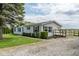 View of the house featuring clean vinyl siding, dark shuttered windows, a quaint deck, and gravel driveway at 1683 W County Road 300 S, Danville, IN 46122