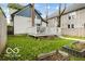 View of the backyard featuring a deck, lush green grass, and planting beds at 1808 E 11Th St, Indianapolis, IN 46201