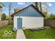 Charming backyard featuring a cute shed with blue door, greenery, and garden beds at 1808 E 11Th St, Indianapolis, IN 46201