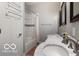 Bright bathroom with a dual sink vanity with marble countertop, framed mirrors, and a shower with tub at 1808 E 11Th St, Indianapolis, IN 46201