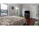 Bright bedroom with hardwood floors, two large windows, and a decorative, neutral-toned bedspread at 1808 E 11Th St, Indianapolis, IN 46201