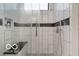 Sleek, walk-in shower with white tile, a black accent, and glass enclosure at 1808 E 11Th St, Indianapolis, IN 46201