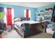 This bedroom features bright blue walls, red curtains, carpeted floors, and ample storage space at 1831 Brook Crossing Way, Indianapolis, IN 46229
