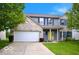 Two-story home features gray siding, a brick facade, blue shutters and a yellow front door at 1831 Brook Crossing Way, Indianapolis, IN 46229