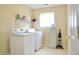 Functional laundry room with washer, dryer, shelving, and ironing board at 1831 Brook Crossing Way, Indianapolis, IN 46229