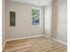 Bedroom with light-brown hardwood floors, light-gray walls, and a window overlooking a house at 202 Mckim Ave, Indianapolis, IN 46201
