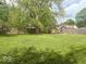 Large backyard with mature trees and a wooden fence, offering privacy at 212 Vasbinder Dr, Chesterfield, IN 46017