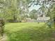 Expansive backyard with lush greenery, mature trees, and a bird feeder, creating a serene retreat at 212 Vasbinder Dr, Chesterfield, IN 46017