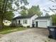 Inviting home with a well-maintained lawn, gravel driveway, and attached garage, perfect for parking at 212 Vasbinder Dr, Chesterfield, IN 46017