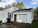 Attached garage with a side door, offering convenient access and extra parking space at 212 Vasbinder Dr, Chesterfield, IN 46017
