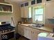 Bright kitchen featuring a window over the sink, stainless steel gas range, and ample cabinet space at 212 Vasbinder Dr, Chesterfield, IN 46017