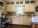 Classic kitchen with stainless steel appliances and white cabinets, complemented by a bright window at 212 Vasbinder Dr, Chesterfield, IN 46017
