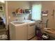 Bright laundry room featuring modern washer and dryer with storage shelves and natural light at 212 Vasbinder Dr, Chesterfield, IN 46017