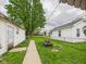 Well-maintained backyard with a fire pit, grassy area, and a walkway between the shed and garage at 2314 Walnut St, Anderson, IN 46016