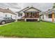 Quaint home with inviting covered porch, complemented by lush green lawn and mature landscaping at 2314 Walnut St, Anderson, IN 46016