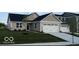 Charming single-story home featuring a two-car garage, a blue door, and a well-manicured front lawn at 2334 Black Rock Cir, Lebanon, IN 46052