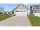 Attached two-car garage featuring a concrete driveway and manicured front lawn at 2334 Black Rock Cir, Lebanon, IN 46052