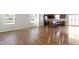 Bright, open-concept living room with modern hardwood floors and access to kitchen with stainless appliances at 2334 Black Rock Cir, Lebanon, IN 46052