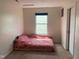 Bedroom featuring a bed with pink floral bedding, a window with blinds, carpeted floors, and white walls at 2350 Harvest Moon Dr, Greenwood, IN 46143