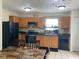 Well-lit kitchen with wood cabinets, black appliances, and a cozy dining area at 2350 Harvest Moon Dr, Greenwood, IN 46143