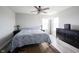 This bedroom is well lit with wood flooring, a ceiling fan, a dresser, two windows, and two bedside lamps at 2628 Lamar Dr, Whitestown, IN 46075