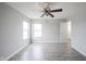 Bright bedroom showcasing large windows, hardwood floors, with a lighted ceiling fan at 2628 Lamar Dr, Whitestown, IN 46075