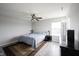 This bedroom is well lit with wood flooring, a ceiling fan, a dresser, a window, and two bedside lamps at 2628 Lamar Dr, Whitestown, IN 46075