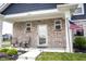 Charming front porch with stone accents, seating, and an American flag offers curb appeal at 2628 Lamar Dr, Whitestown, IN 46075