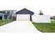 Attached two-car garage with a white door and a long, wide driveway offer parking convenience at 2628 Lamar Dr, Whitestown, IN 46075