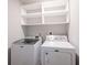 Convenient laundry room features a modern white washer and dryer set with storage shelves above at 2628 Lamar Dr, Whitestown, IN 46075