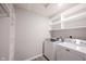 Well-lit laundry room with modern white washer and dryer, alongside built-in shelving for optimal organization at 2628 Lamar Dr, Whitestown, IN 46075