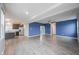Open concept living room with wood floors, blue accent wall, and kitchen view at 2628 Lamar Dr, Whitestown, IN 46075