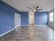 Spacious living room with gray wood floors, blue accent wall, and modern ceiling fan at 2628 Lamar Dr, Whitestown, IN 46075