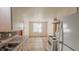 Bright kitchen with white cabinets and appliances, and tile flooring leading to dining area at 268 S Grant Ave, Indianapolis, IN 46201