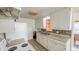 Traditional-style kitchen features white cabinets, granite countertops, and stainless steel double basin sink at 268 S Grant Ave, Indianapolis, IN 46201