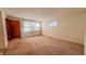 Spacious living room with carpet flooring, large windows, and a wooden entry door at 268 S Grant Ave, Indianapolis, IN 46201