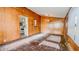 A vintage room with wood paneled walls leading to the kitchen and windows at 268 S Grant Ave, Indianapolis, IN 46201