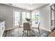Dining area with glass table, white chairs, windows and door leading to the patio at 2823 Somerset Bay, Indianapolis, IN 46240