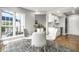 Bright dining area with glass table, white chairs, windows and open to the kitchen at 2823 Somerset Bay, Indianapolis, IN 46240