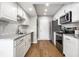 Galley kitchen featuring white cabinets, granite countertops, stainless steel appliances, and hardwood flooring at 2823 Somerset Bay, Indianapolis, IN 46240