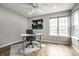 Well-lit home office with a ceiling fan, gray walls, wood flooring, windows, tulips art, and desk at 2823 Somerset Bay, Indianapolis, IN 46240