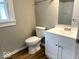 Bathroom featuring a white vanity, modern faucet, and a standard toilet at 2924 Main St, Anderson, IN 46016