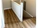 Hallway with updated wood flooring and stairs with white banister leading downstairs at 2924 Main St, Anderson, IN 46016