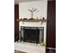 Cozy fireplace with white painted bricks, dark mantle, and a decorative screen at 2935 Flintwood Dr, Columbus, IN 47203