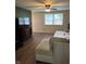 Bright living room featuring laminate floors, a ceiling fan, a TV, and a large window at 2935 Flintwood Dr, Columbus, IN 47203