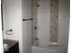 Updated bathroom with a tiled shower, granite countertop, and modern fixtures at 3008 W Grace Ln, Muncie, IN 47304